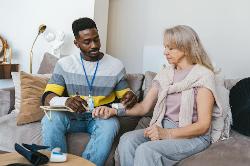 A senior care specialist does an in-house health checkup for a senior.